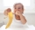 bébé en train de manger une banane dans sa chaise haute